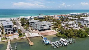 A coastal residential area with houses, a dock, and a pier. - Bay Pearl - Bradenton Beach Condo by Anna Maria Life Vacation Rentals (Bradenton Beach)