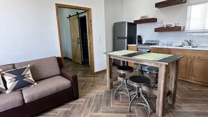 Una cocina moderna con comedor, sofá y suelo con estampado de espiga.