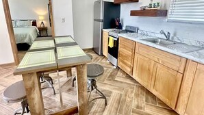 Una cocina compacta con refrigerador, estufa y armarios de madera.