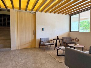 A modern interior with a wooden ceiling, a sliding door, and a seating area with a table and chairs. - Loft Moderno en Mazatlán, Salvia Hábitat by GPS (Mazatlán)