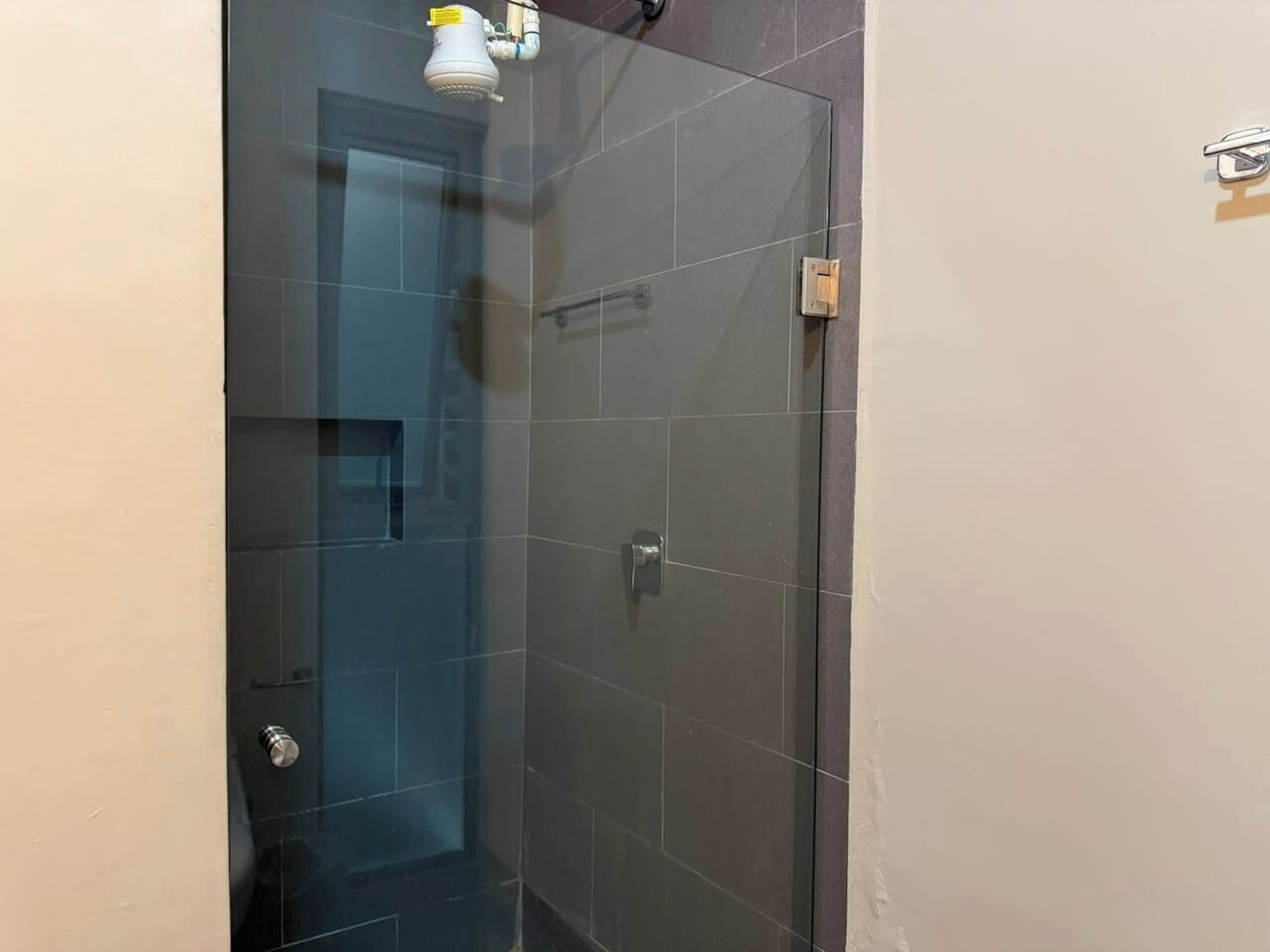 A glass-enclosed shower stall with a visible showerhead and a control panel.
