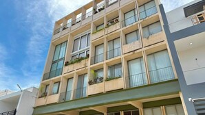 Un immeuble à plusieurs étages doté de balcons, de grandes fenêtres et d’un toit plat.