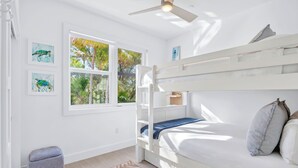 A bunk bed with a window, a small ottoman, and artwork on the wall. - The Lighthouse | Ocean and Pool Views, Game Room, Pool + Dock Access (Islamorada)