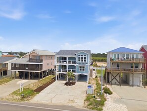 A residential area with houses featuring balconies and waterfront views. - Pelican Parade: Ocean View, Pet-Friendly 5 Bedroom Luxury Retreat with Private Pool and Elevator (Oak Island)