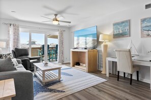A modern living room with a sofa, armchair, coffee table, and a desk with a lamp. - Enjoy stunning partial Gulf views from La Mirage 301 in Port Aransas, TX. (Port Aransas)