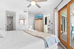 A bedroom with a bed, a ceiling fan, a television, a wardrobe, and a sliding glass door to the outside. - Enjoy stunning partial Gulf views from La Mirage 301 in Port Aransas, TX. (Port Aransas)
