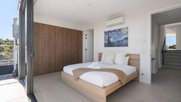A modern bedroom with a large bed, a wooden wardrobe, and a painting on the wall.