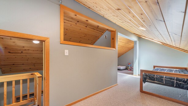 A bedroom with a wooden ceiling, a bunk bed, and a small wooden crib. - New- Cozy Pathway Pines (Truckee)