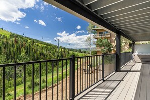 A balcony with a view of a ski lift, a building with balconies, and a forested hillside. - FPX Legacy Lodge - One of a kind & Renovated! ~Ski In/Out~  Private HT, Club Amenities & EZCancel (Steamboat Springs)
