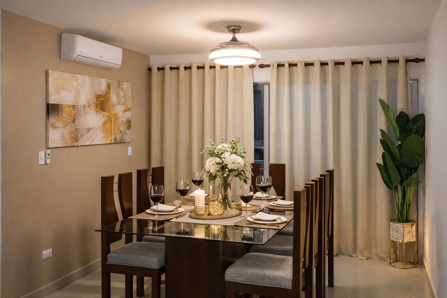 A dining area with a glass table, wooden chairs, a vase with flowers, and a ceiling fan.