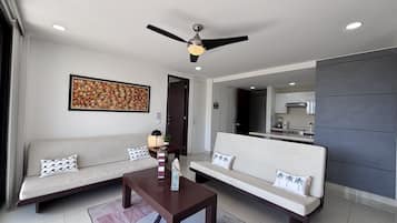 A modern living room with a sofa, a coffee table, and a ceiling fan.