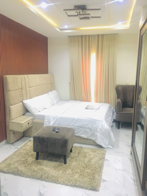 A bedroom with a bed, a nightstand, a chair, a mirror, and a carpet. - Vintage hight (Lekki)