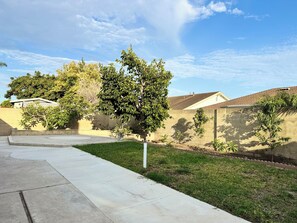 A residential area with a concrete pathway, green grass, and trees. - Cozy 2-bedroom unit in central Westminster, Orange County. (Westminster)