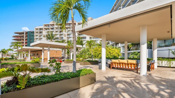A modern hotel with outdoor seating, palm trees, and a covered patio area. - 1BR, 2BA condo in Marina Vallarta, Puerto Vallarta. (Puerto Vallarta)