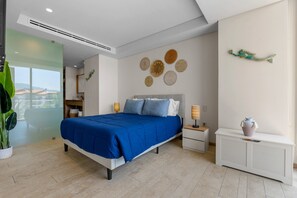A modern bedroom with a large bed, bedside tables, a nightstand, a decorative wall, and a view through a glass door. - 1BR, 2BA condo in Marina Vallarta, Puerto Vallarta. (Puerto Vallarta)