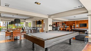 A pool table in a modern indoor space with a bar area and seating. - 1BR, 2BA condo in Marina Vallarta, Puerto Vallarta. (Puerto Vallarta)