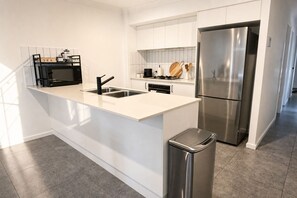 A modern kitchen with a stainless steel refrigerator, a built-in oven, and a coffee maker. - Casa Oliva | Spacious Retreat Near Toranga Zoo (Dubbo)