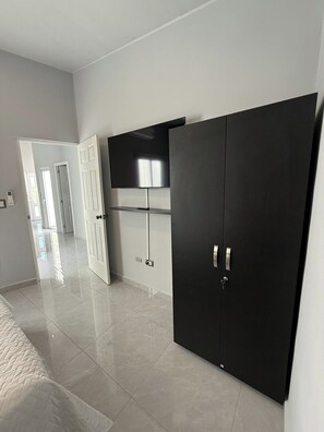 Ein Schlafzimmer mit einem Bett, einem Kleiderschrank und einem Fernseher.