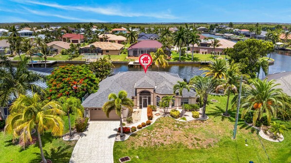 A residential area with houses, a body of water, and a prominent red house marker.