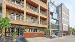 A multi-story hotel with balconies, a sign for 'PALETTE HOTEL,' and a 'CHECIN' restaurant. - Palette Hotel Millennium City Gurugram (Gurugram)