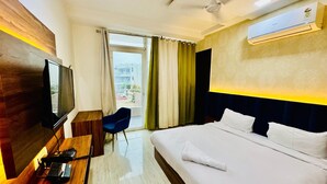 A hotel room with a bed, a desk with a television, a chair, and an air conditioning unit. - Palette Hotel Millennium City Gurugram (Gurugram)