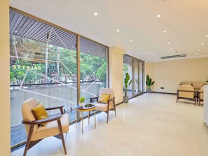 A spacious hotel lobby with large windows, a reception desk, and seating areas. - Palette Hotel Millennium City Gurugram (Gurugram)