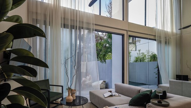 A modern living room with a sofa, a coffee table, and a potted plant. - Nexa Townhouse 08 (Badung)