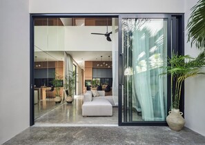 Um interior moderno com uma porta de correr de vidro que dá para uma sala de estar e uma área de refeições.