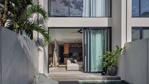 A modern house with a pool, a dining area, and a living room. - Nexa Townhouse 08 (Badung)