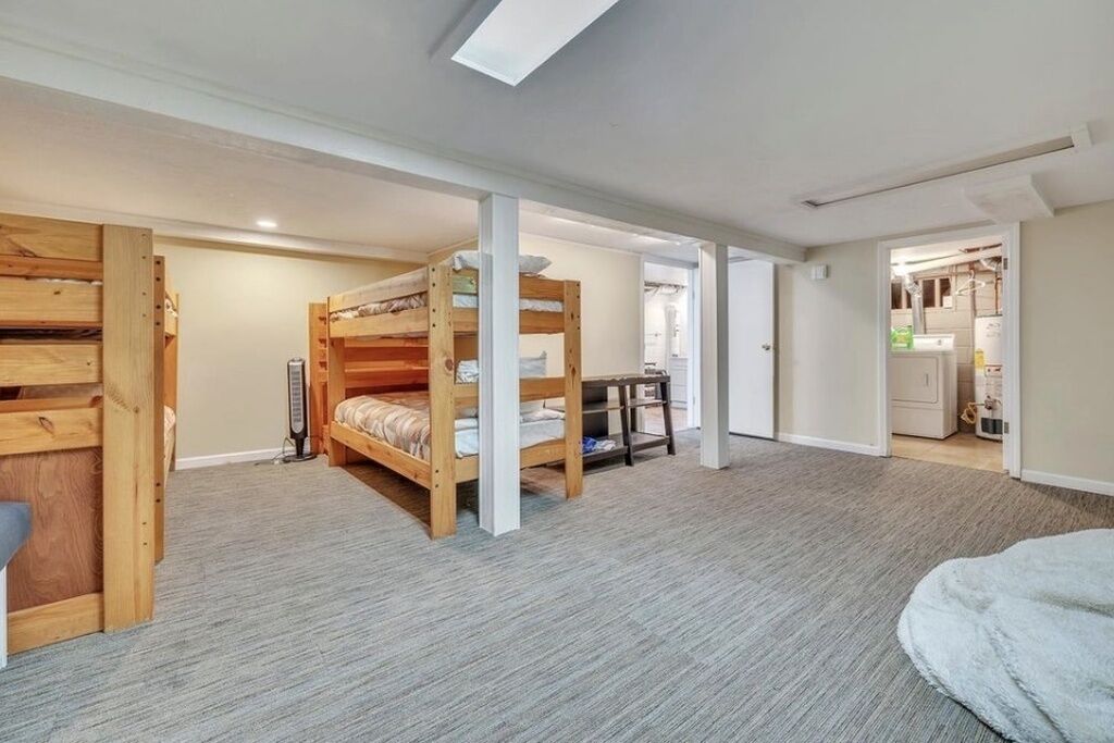 A room with bunk beds, a small table, and a radiator.