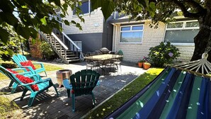 A patio with outdoor furniture, a hammock, and a staircase leading to a building. - Views @ Four Winds (Taupō)