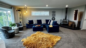 A modern living room with a sectional sofa, a round rug, and a fireplace. - Views @ Four Winds (Taupō)