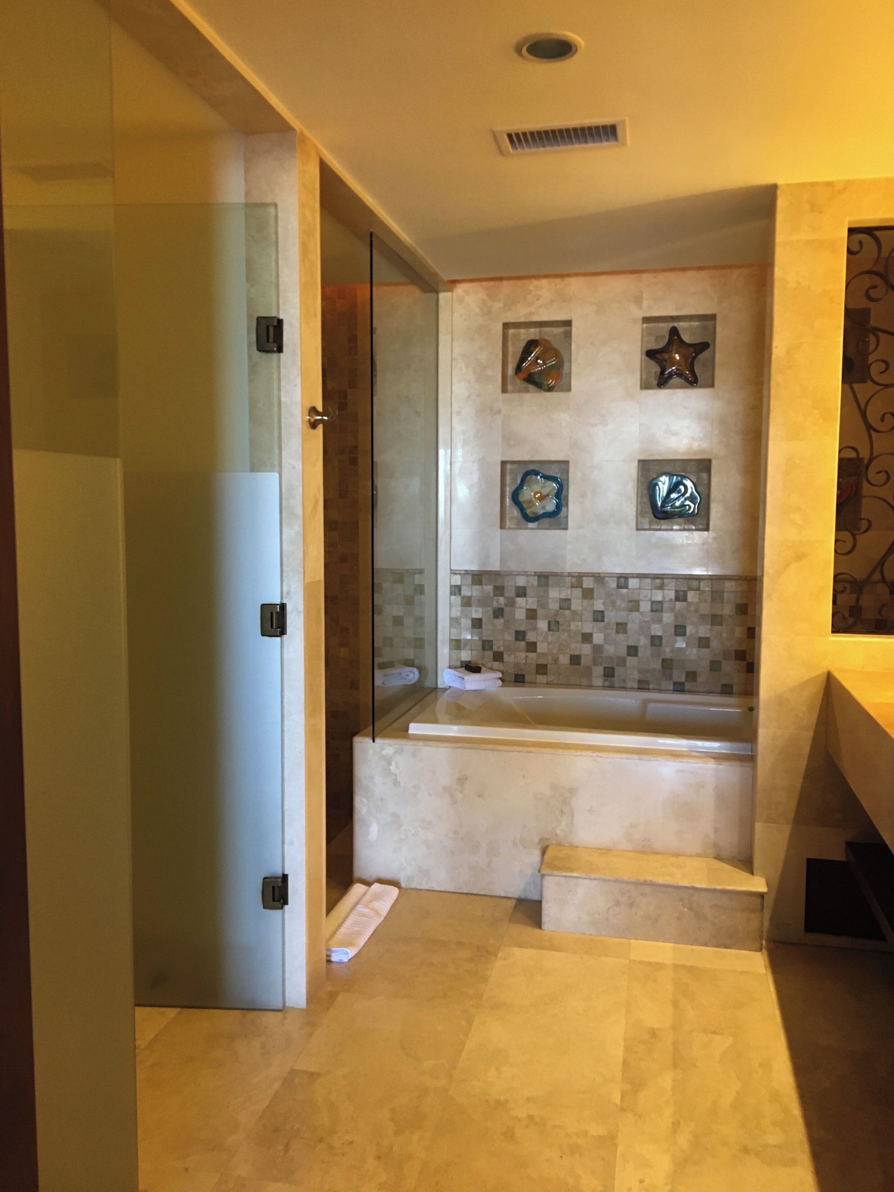 Une salle de bain moderne avec une douche à l’italienne, une baignoire et des carreaux décoratifs.
