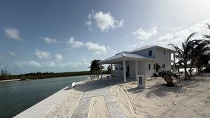 A beachfront property with a covered patio, a pool, and a view of the ocean. - Enchanting Luxury Beachfront Villa Stillwater in Sandy Point views of Parrot Cay (Sandy Point)