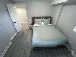 A bedroom with a bed, bedside table, lamp, and a door leading to another room. - Entire home in Brampton, Canada
2 guests1 bedroom1 bed1 bath (Brampton)