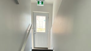 A staircase leading to a door with a window, white walls, and a handrail. - Entire home in Brampton, Canada
2 guests1 bedroom1 bed1 bath (Brampton)