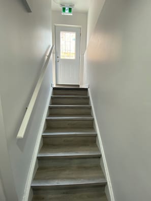 A staircase leading to a door with a window, white walls, and a handrail. - Entire home in Brampton, Canada
2 guests1 bedroom1 bed1 bath (Brampton)