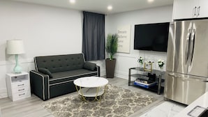A modern living room with a sofa, a coffee table, a flat-screen TV, a refrigerator, and a potted plant. - Entire home in Brampton, Canada
2 guests1 bedroom1 bed1 bath (Brampton)