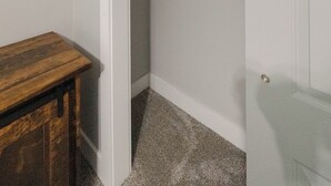 Ein Kleiderschrank mit Kleiderstange und einem Holztisch.
