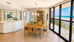 A spacious dining area with a view of the beach through large windows. - Sandpiper 1005: Oceanfront 3BR condo with pool, hot tub, and beach access in Port Aransas. (Port Aransas)