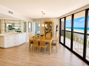 Ein geräumiger Essbereich mit Blick auf den Strand durch große Fenster.