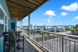 Ein Balkon mit Blick auf eine Küstenlandschaft, ausgestattet mit einem Holzboden und einem Metallgeländer.