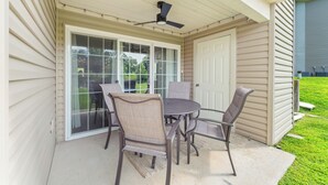 A covered patio with a table and chairs, a sliding glass door, and a ceiling fan. - Casa de Cozy - Resort Condo Minutes from Branson & Lake Taneycomo (Branson)