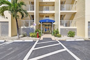 A multi-story hotel with a blue awning and a palm tree in the foreground. - Sugar Sand Beachfront Condo, Spectacular Gulf Views, 24' Lanai, 2BR/2BA, #433 (Fort Myers Beach)