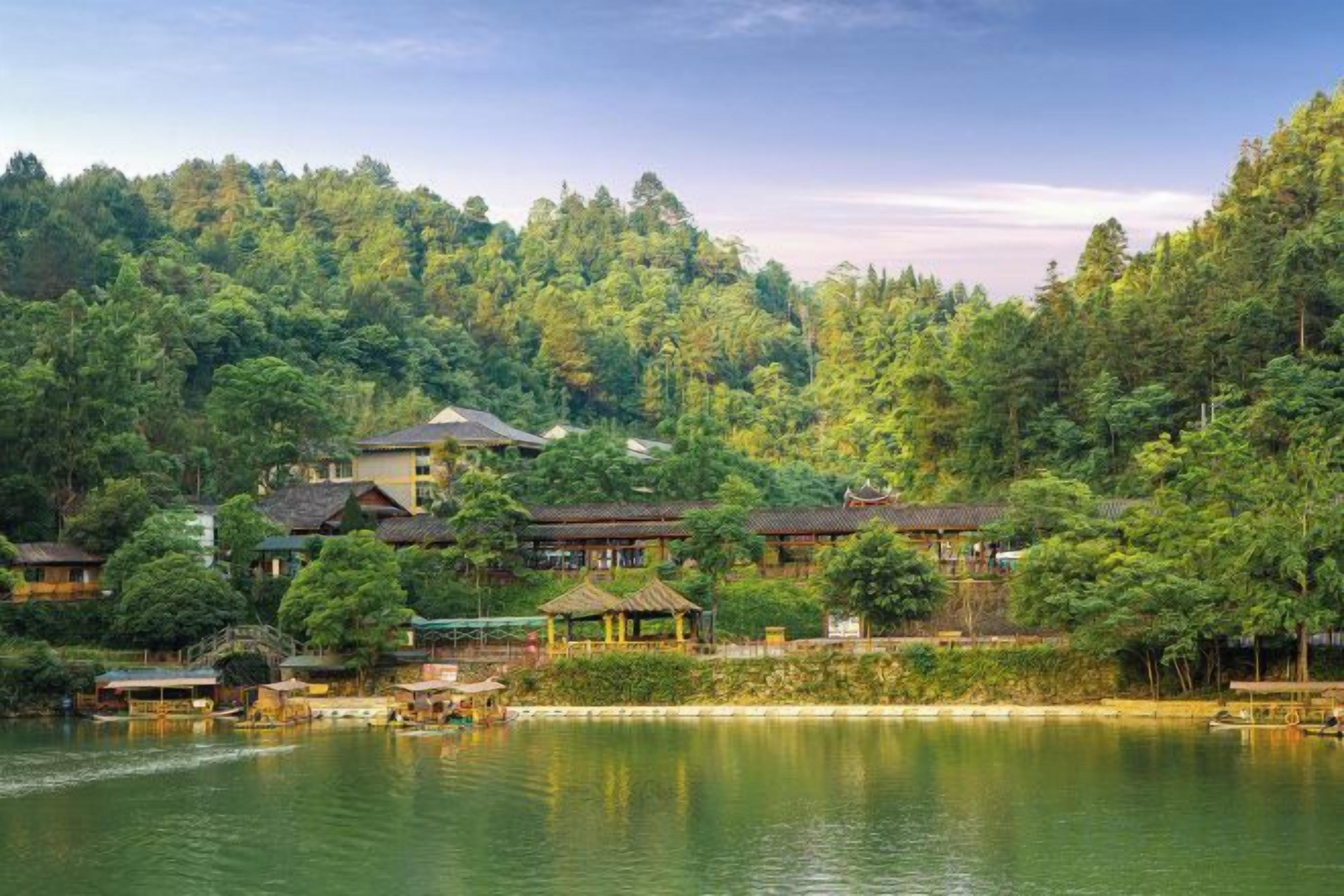 A lakeside property with traditional architecture, a gazebo, and a wooden dock.