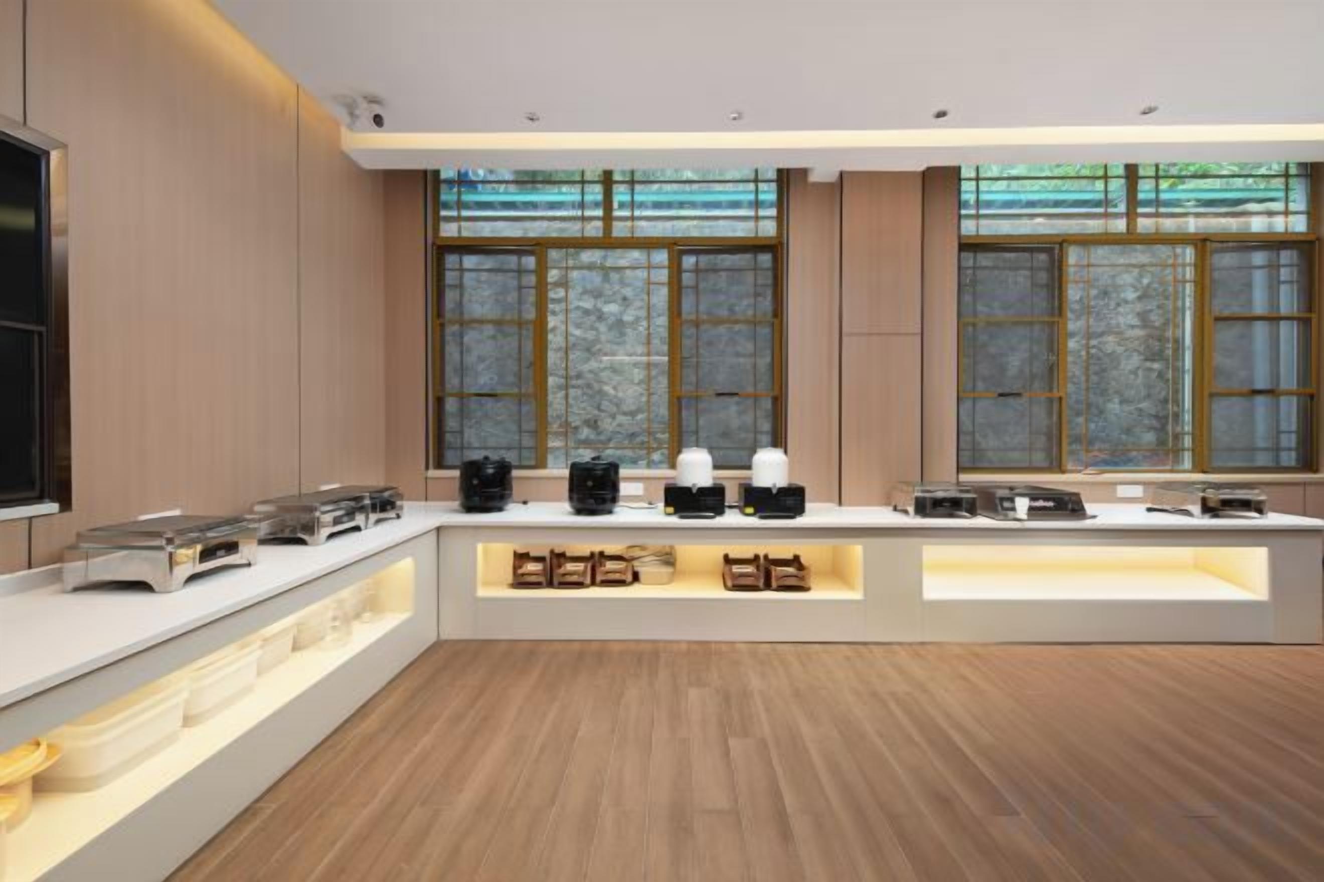 Una cocina moderna con una isla central, electrodomésticos integrados y grandes ventanales.
