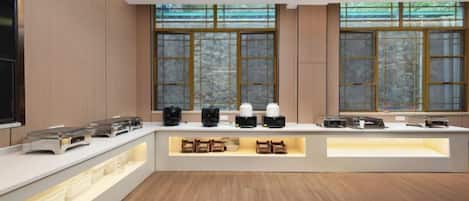 A modern kitchen with a central island, built-in appliances, and large windows.