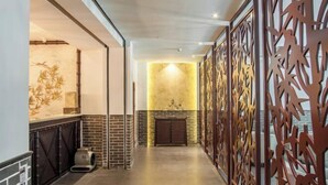 A hallway with a fireplace, decorative wall panels, and a tiled floor. - Libo Daqikong Bamboo Garden Boutique Hotel (East Gate Ticket Hall Store of Xiaoqikong Scenic Area) (Libo)