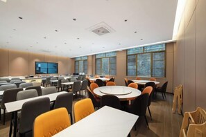 A conference room with multiple tables and chairs, large windows, and a flat-screen TV. - Libo Daqikong Bamboo Garden Boutique Hotel (East Gate Ticket Hall Store of Xiaoqikong Scenic Area) (Libo)