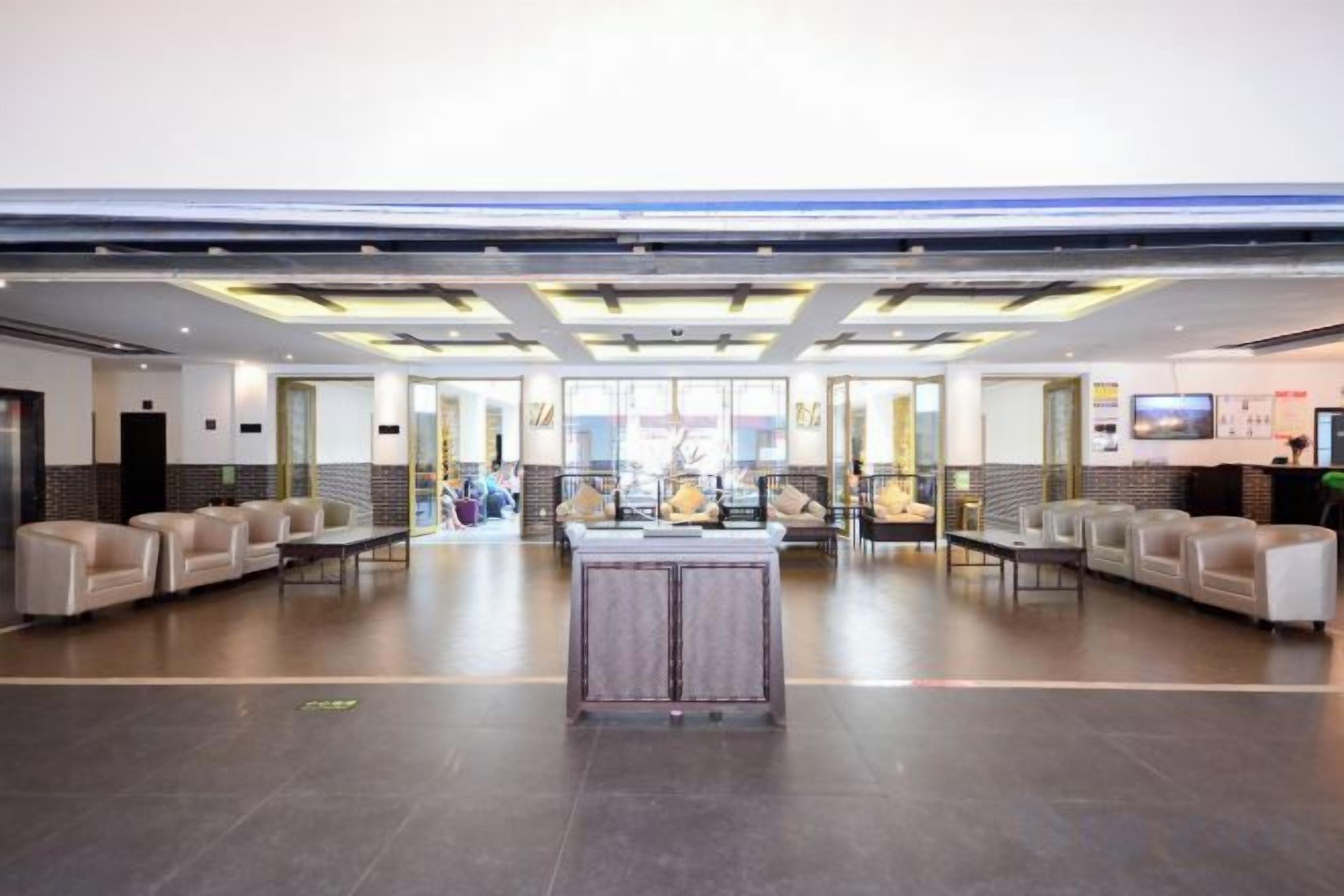 A spacious lobby with a reception desk, seating area, and a large window.